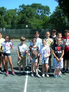 group of kids standing on tennis court